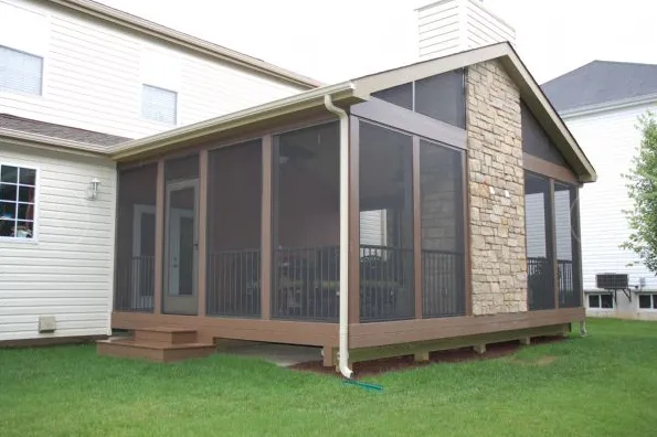 Enclosed backyard porch with screened walls, stone accent wall, and a small wooden deck attached to a house.