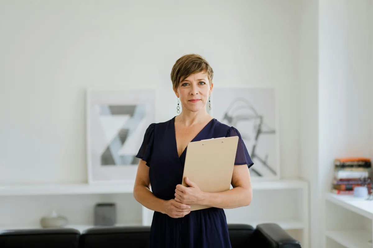Woman adding sticky notes to a dark wall.