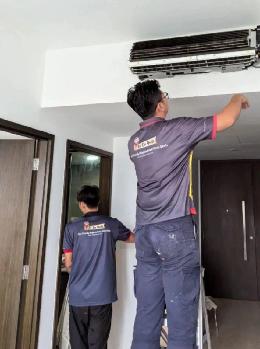 Aircon Uncle technicians performing aircon servicing for a Xiaohongshu customer, inspecting and cleaning a wall-mounted unit to ensure efficient cooling and optimal performance