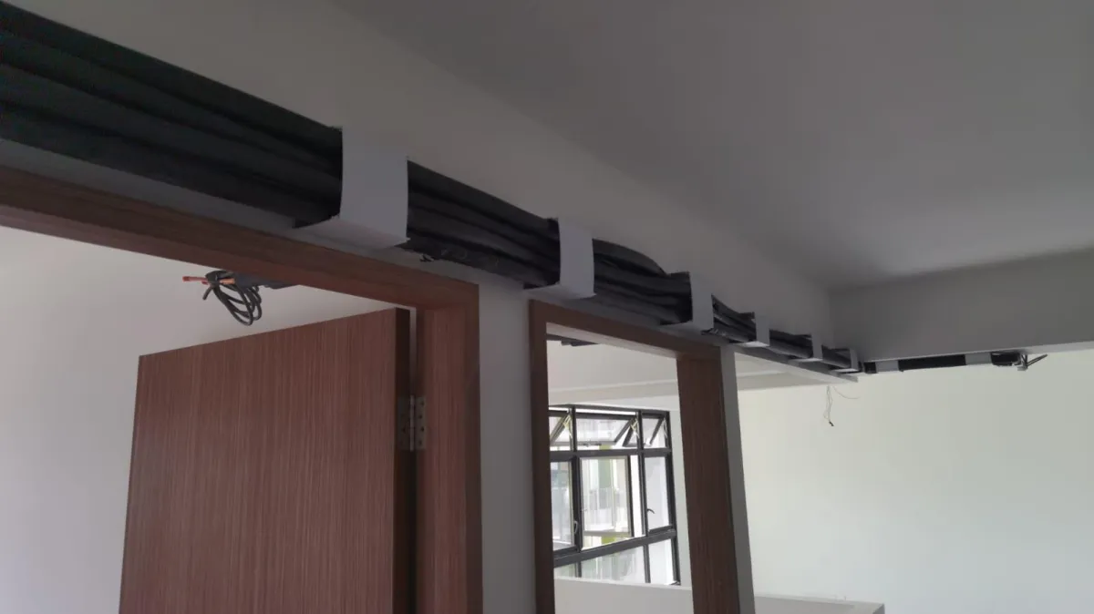 Professional Aircon technician installing a wall-mounted aircon unit, with protective plastic sheeting used to ensure cleanliness during the owner renovation process.