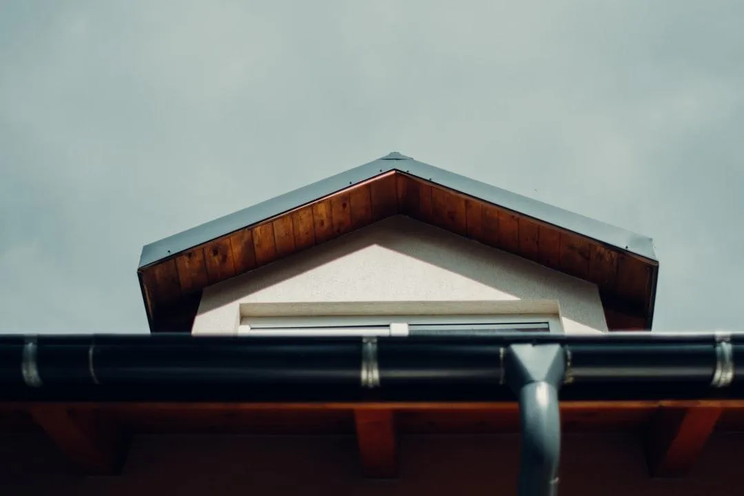 Skilled contractors installing seamless aluminum gutters on a modern home, ensuring proper drainage and home protection with a durable and efficient gutter system.