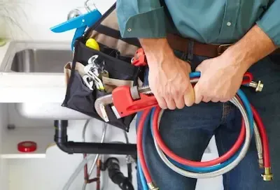 Emergency plumber carrying pipe wrench and supply hoses for service call in Pickerington by Pickerington Emergency Plumbers