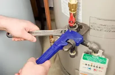 Pipe wrench tightening valve connection on residential water heater in Pickerington
