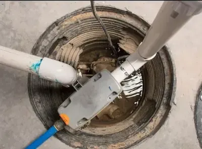 Sump pump and discharge pipes installed inside basement pit during repair service