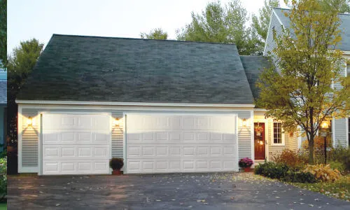 Older, plain, white, metal garage doors on a house in the Flathead Valley