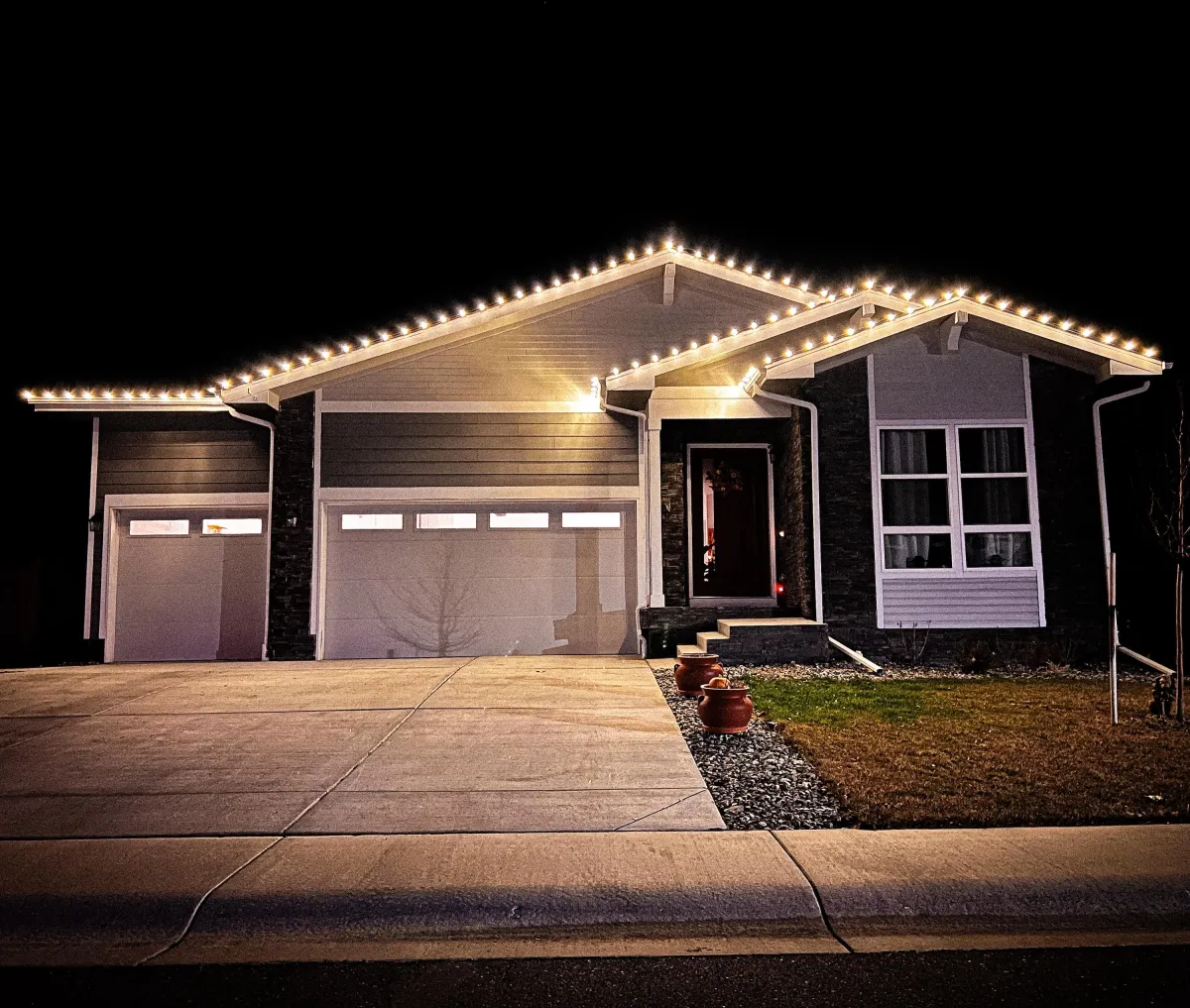 Timnath home with warm white C9 LED roofline Christmas lights professionally installed.