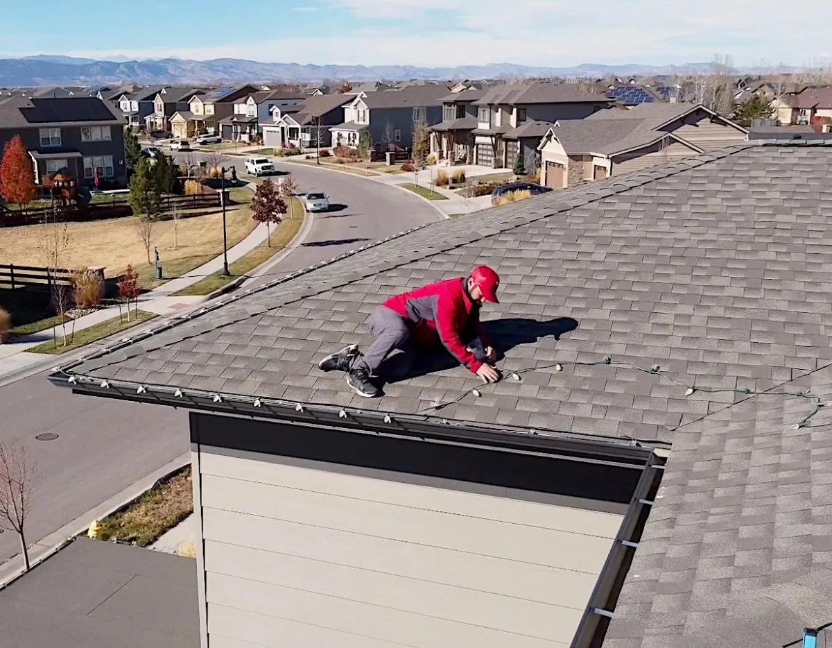 Owners Justin Noyes of Lighting Colorado’s Christmas putting lights up on the roof line