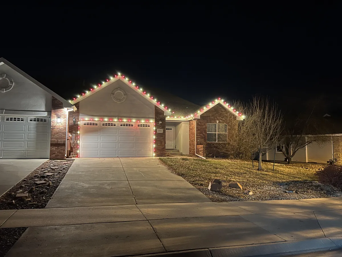 Greeley home with warm white and red C9 LED roofline Christmas lights professionally installed.