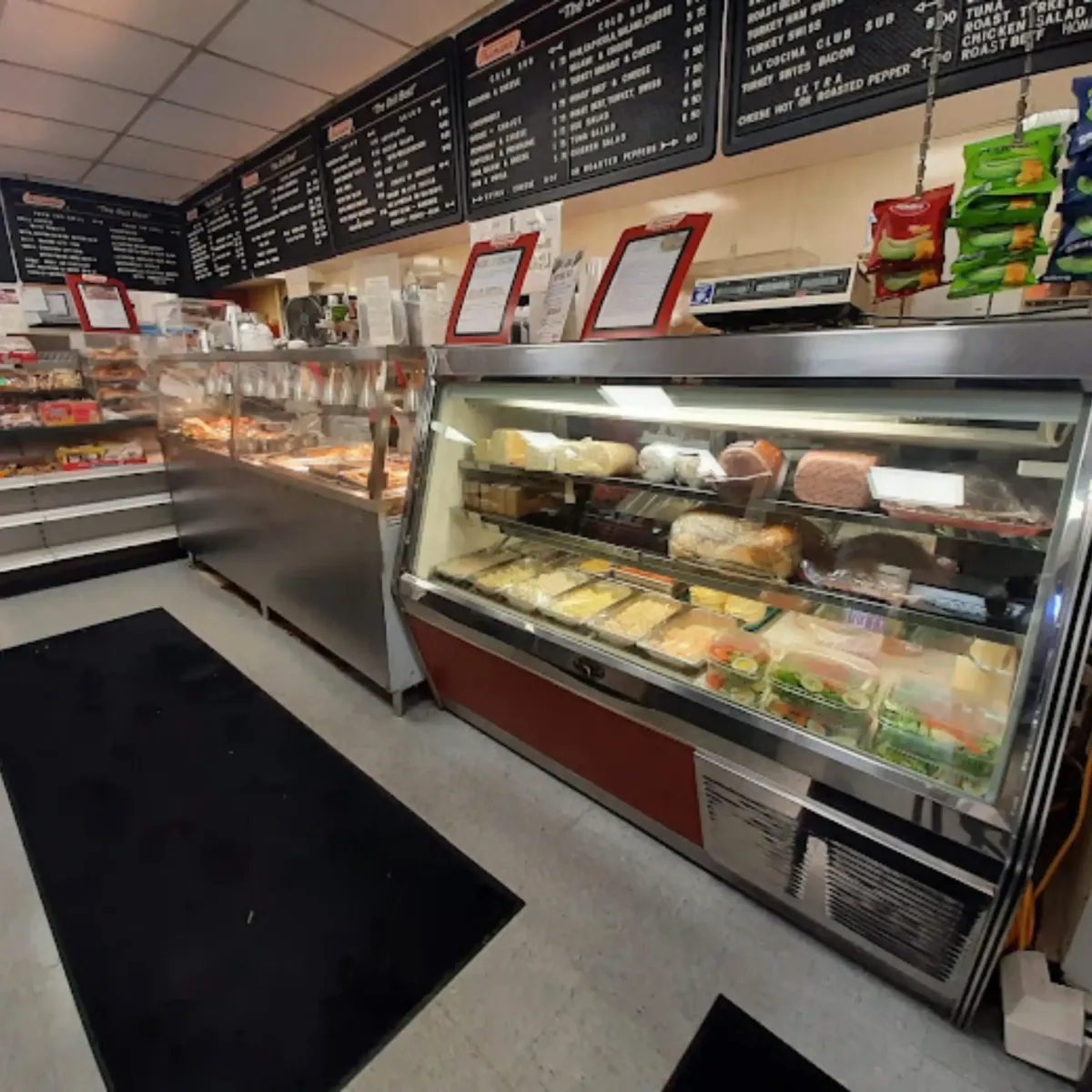 A variety of freshly prepared hot Latin dishes displayed in La Cocina’s buffet-style serving station, featuring seasoned meats, rice, beans, and other homestyle favorites.