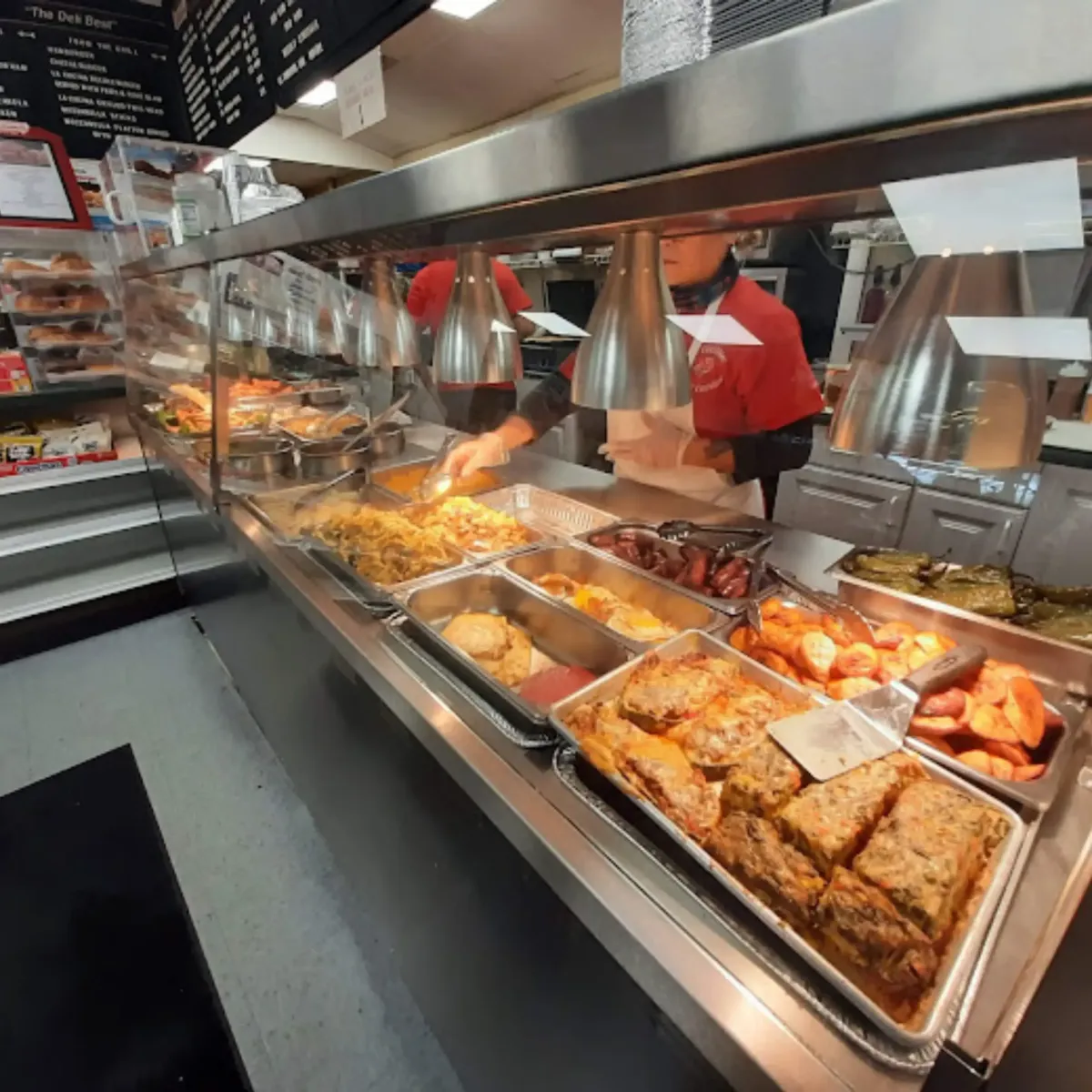 An inside look at La Cocina’s deli and food counter, displaying fresh ingredients, meats, and Latin-inspired dishes ready to be served.