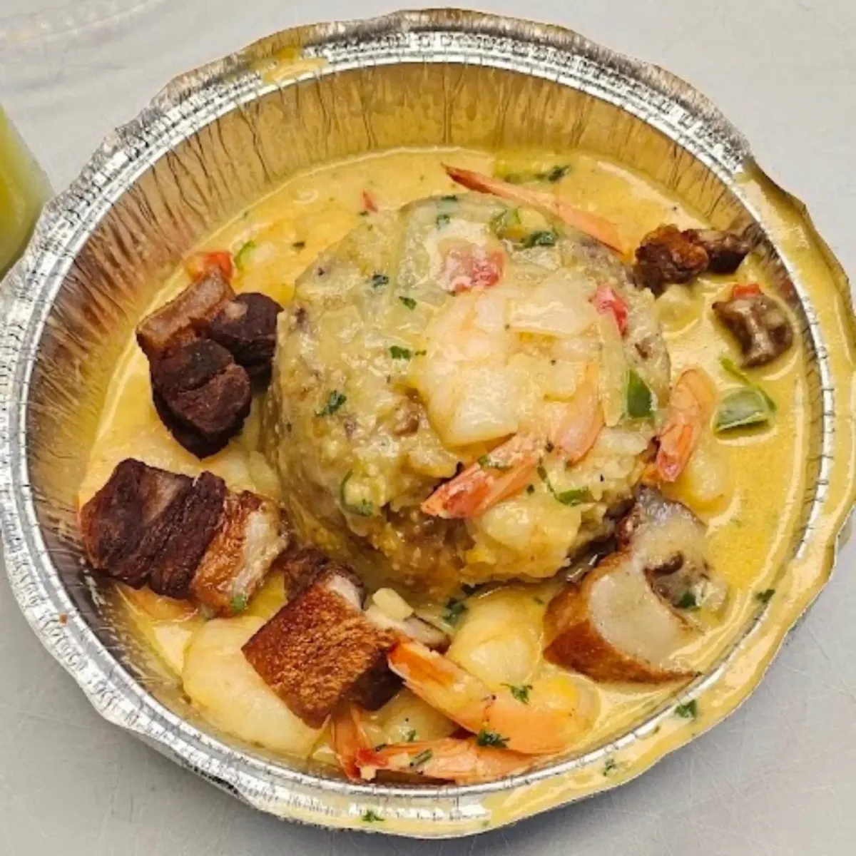 A beautifully plated mofongo dish with shrimp, crispy pork, and a creamy, savory sauce, showcasing La Cocina’s take on a traditional Puerto Rican favorite.
