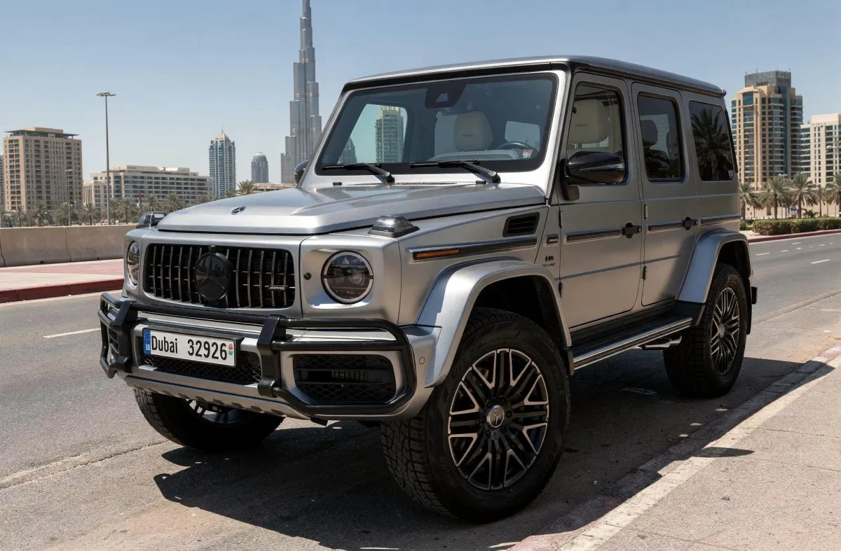 Silver Mercedes AMG G63 parked on a Dubai city road with Burj Khalifa in the background