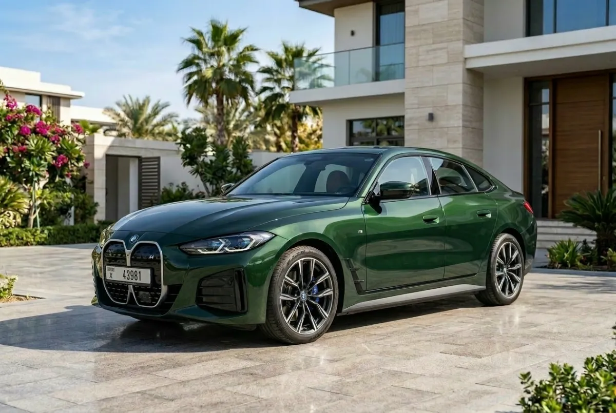 Green BMW i4 Gran Coupé parked outside a luxury Dubai villa