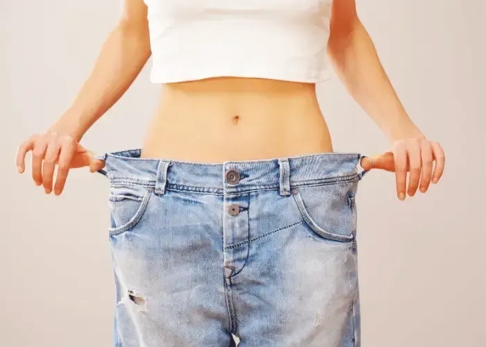 Woman's hip with oversized pants indicating successful weight loss in Gainesville, GA