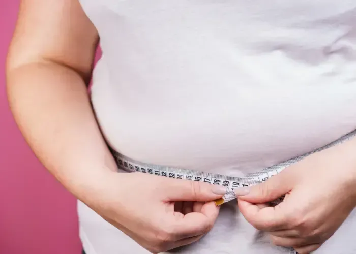 Overweight patient holding measuring tape in Gainesville GA