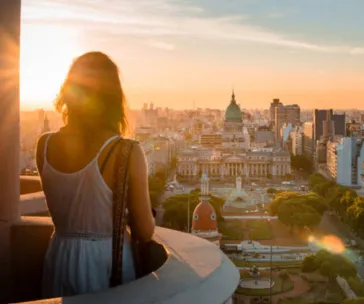 Woman overlooking Buenos Aires city skyline at sunset with view of the Argentine National Congress building