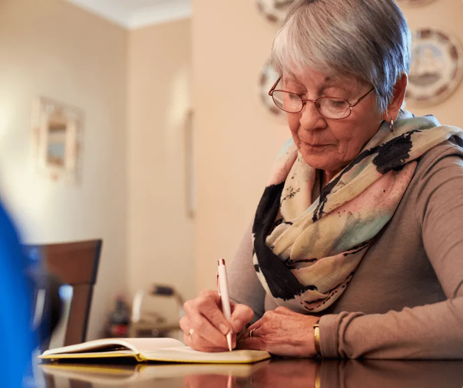 Smiling mature woman sitting and writing book