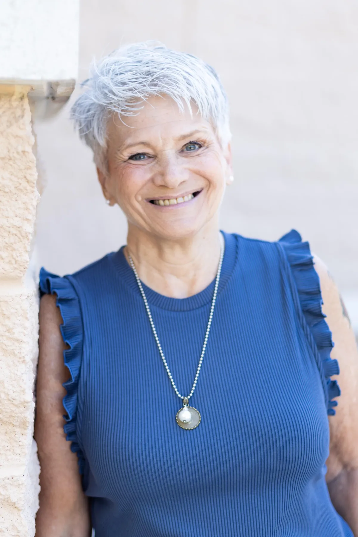 Vickie Turley leaning against stone wall