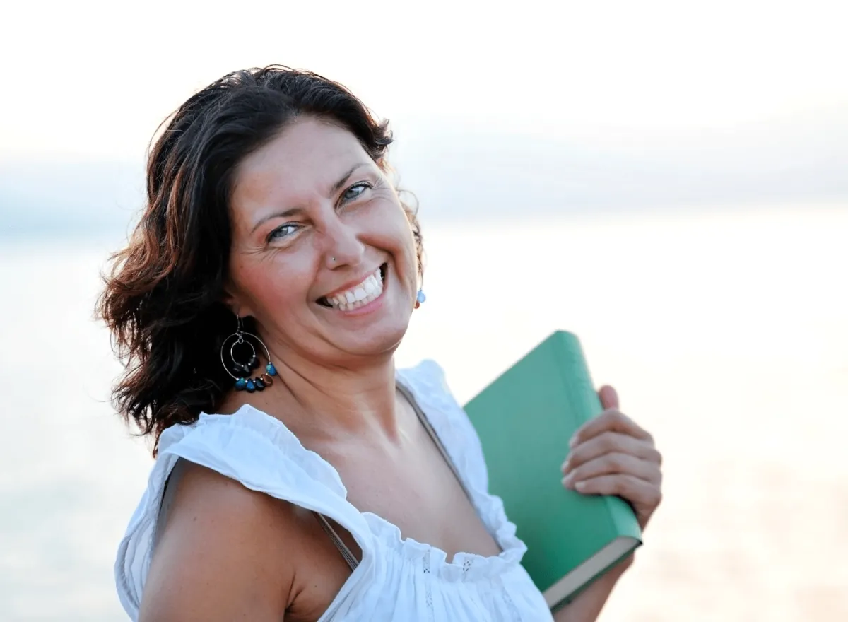 Smiling woman holing self-published book