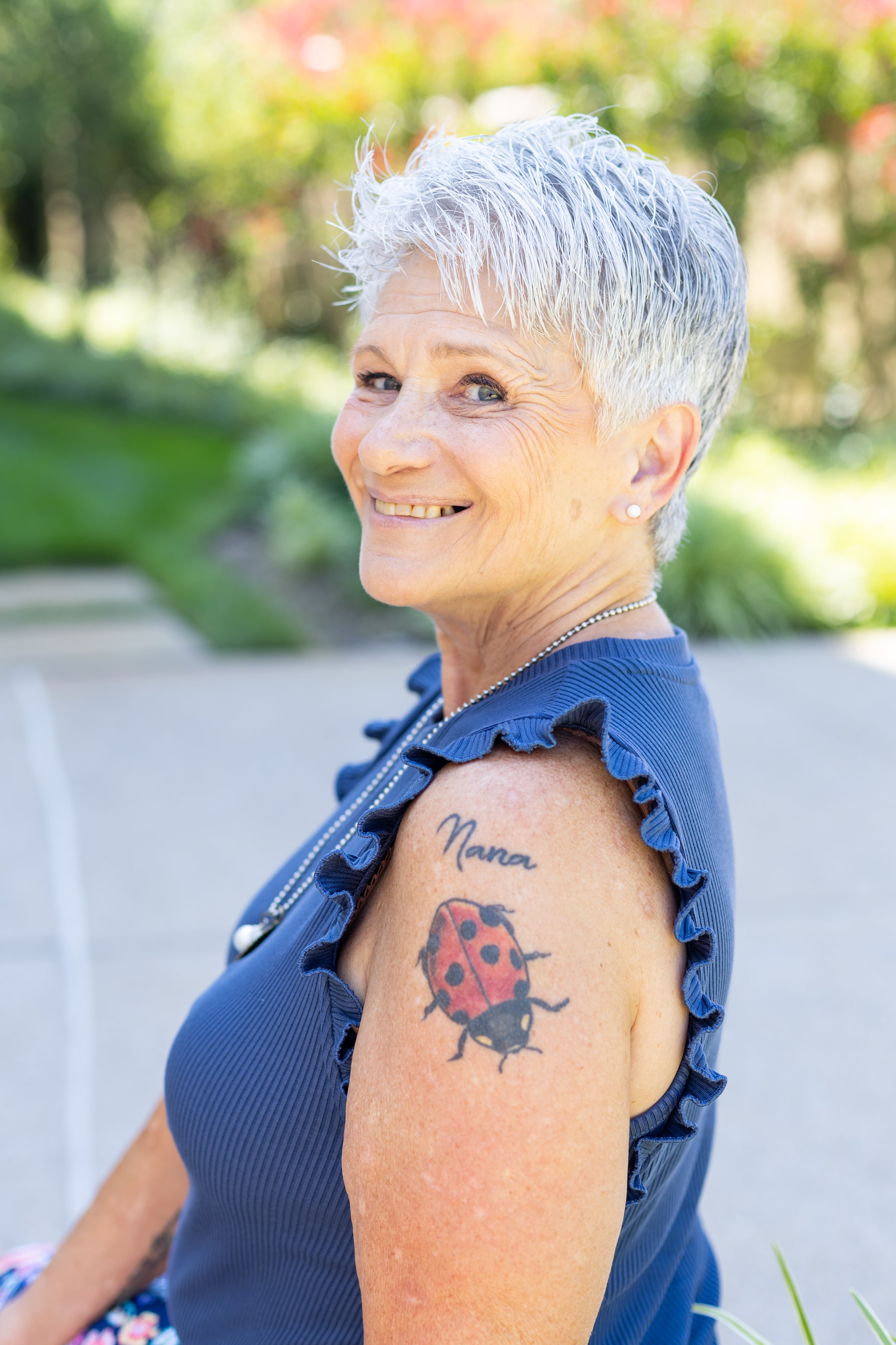 Vickie Turley looking over shoulder with name Nana and lady bug tattoo  