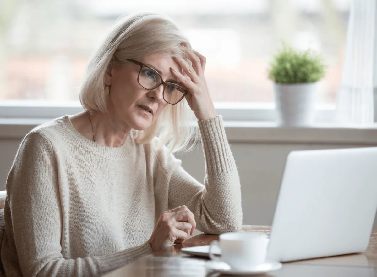 Frustrated mature woman trying to write book on laptop