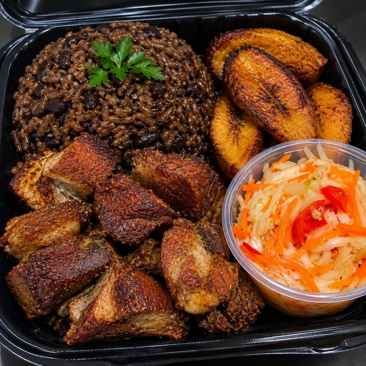 Traditional Haitian Griot complete platter with fried pork, banan peze, and pikliz