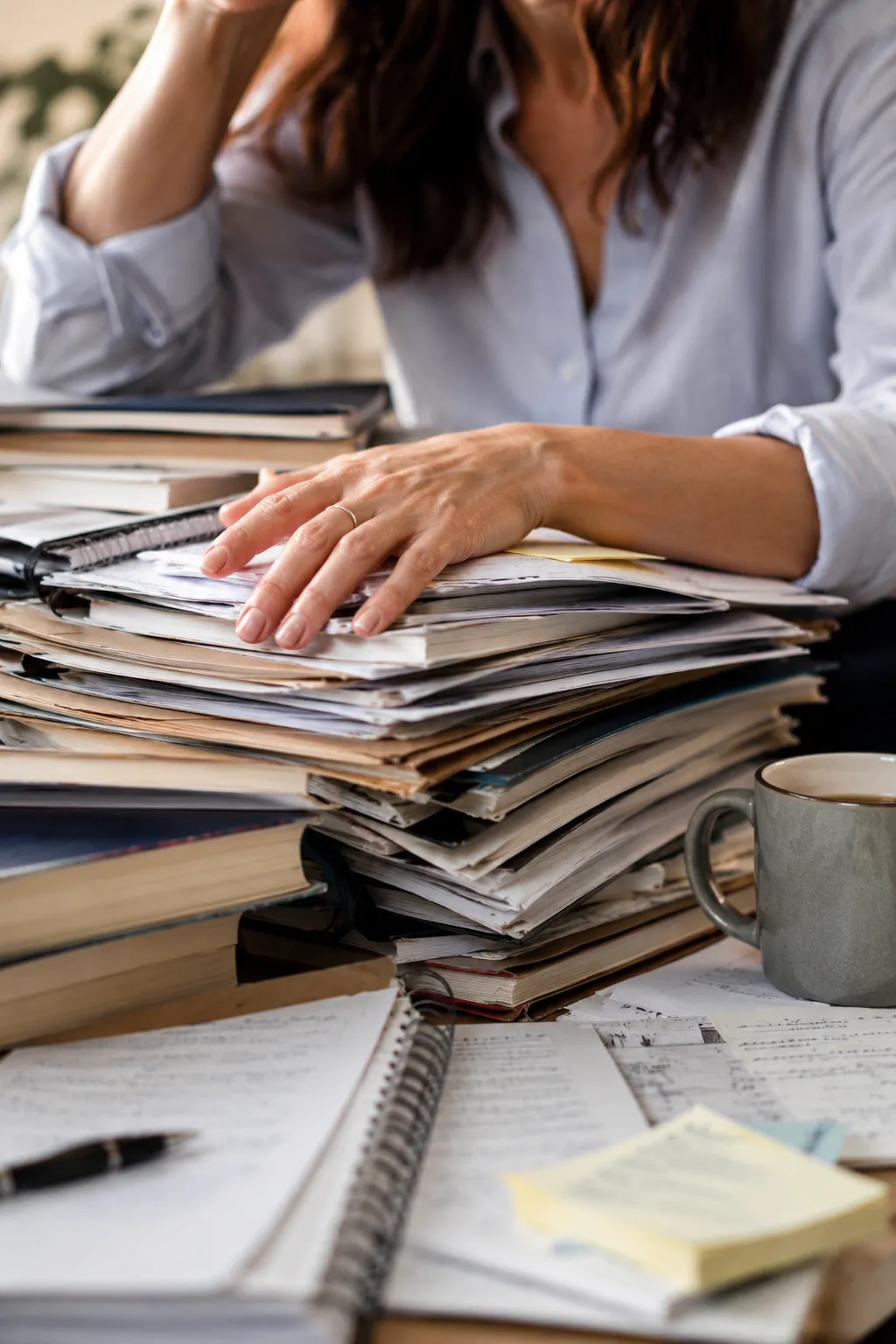Photo of a woman sitting at her desk overwhelmed by work