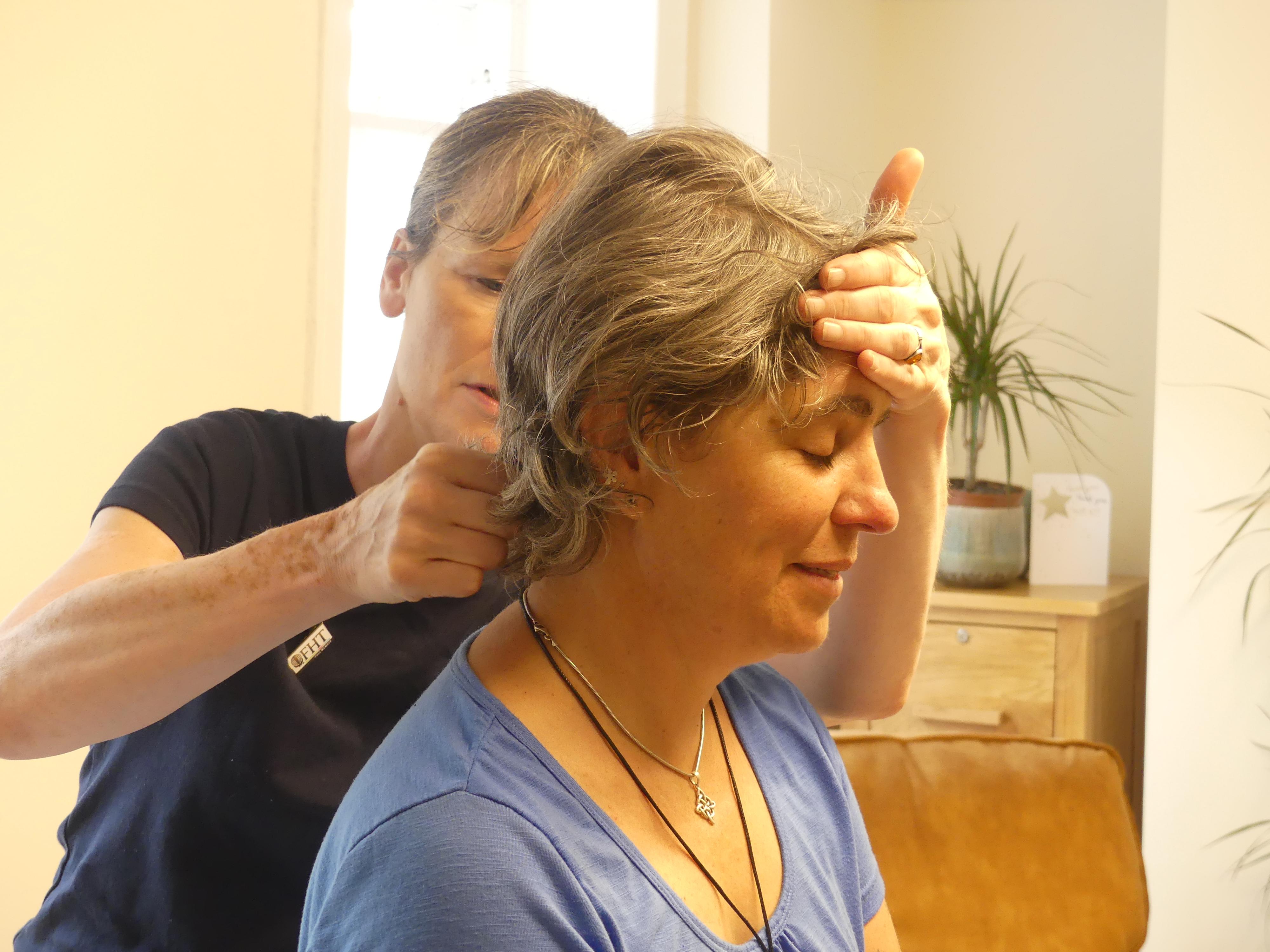 Photo showing the kinesiologist Hilary Dancing treating the client's head