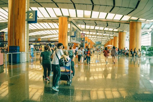 Busy airport terminal during spring break travel with families preparing child travel consent documents