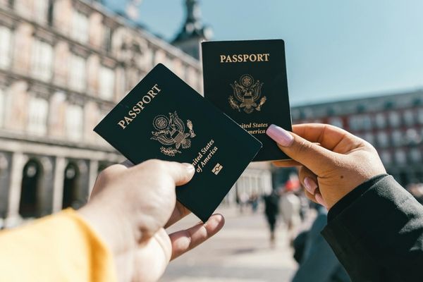 Parents holding passports while preparing notarized travel consent forms for international spring break travel with minors