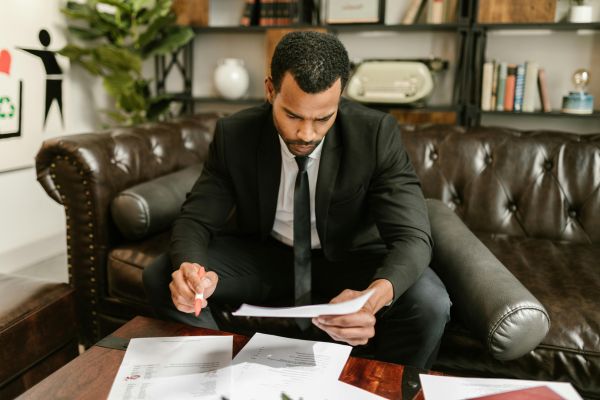 Business professional reviewing company documents and contracts during Q1 business clean-up and notarization preparation