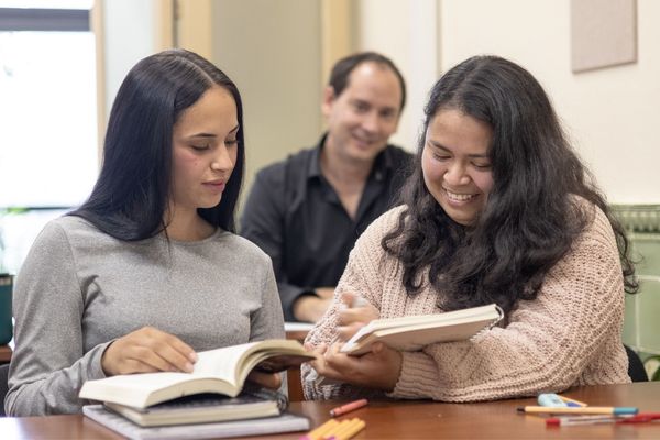 2 incoming college student with their parent preparing their college documents