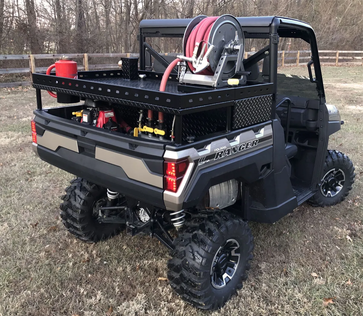 TrailForge UTV deployed on graded terrain with crew in background, three-quarter angle in natural light.