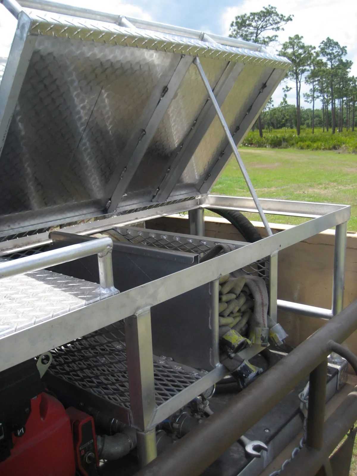 Southern Rough wildland fire truck overhead rack with hinged diamond plate storage compartment and quick-lay hose tray for rapid deployment