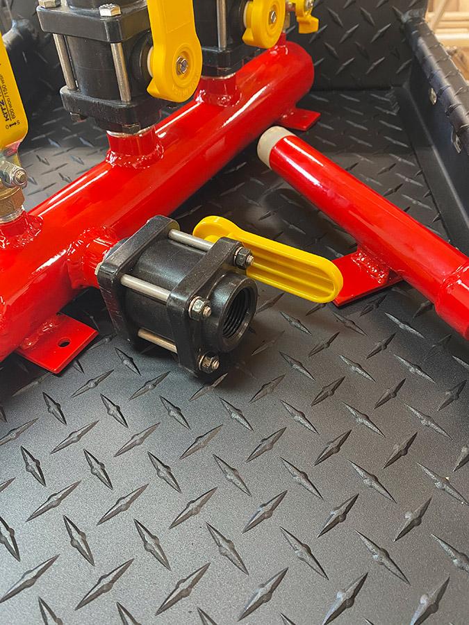 Southern Rough custom aluminum wildland fire manifold with red powder coat finish, yellow-handled ball valves, and threaded connections on diamond plate bed