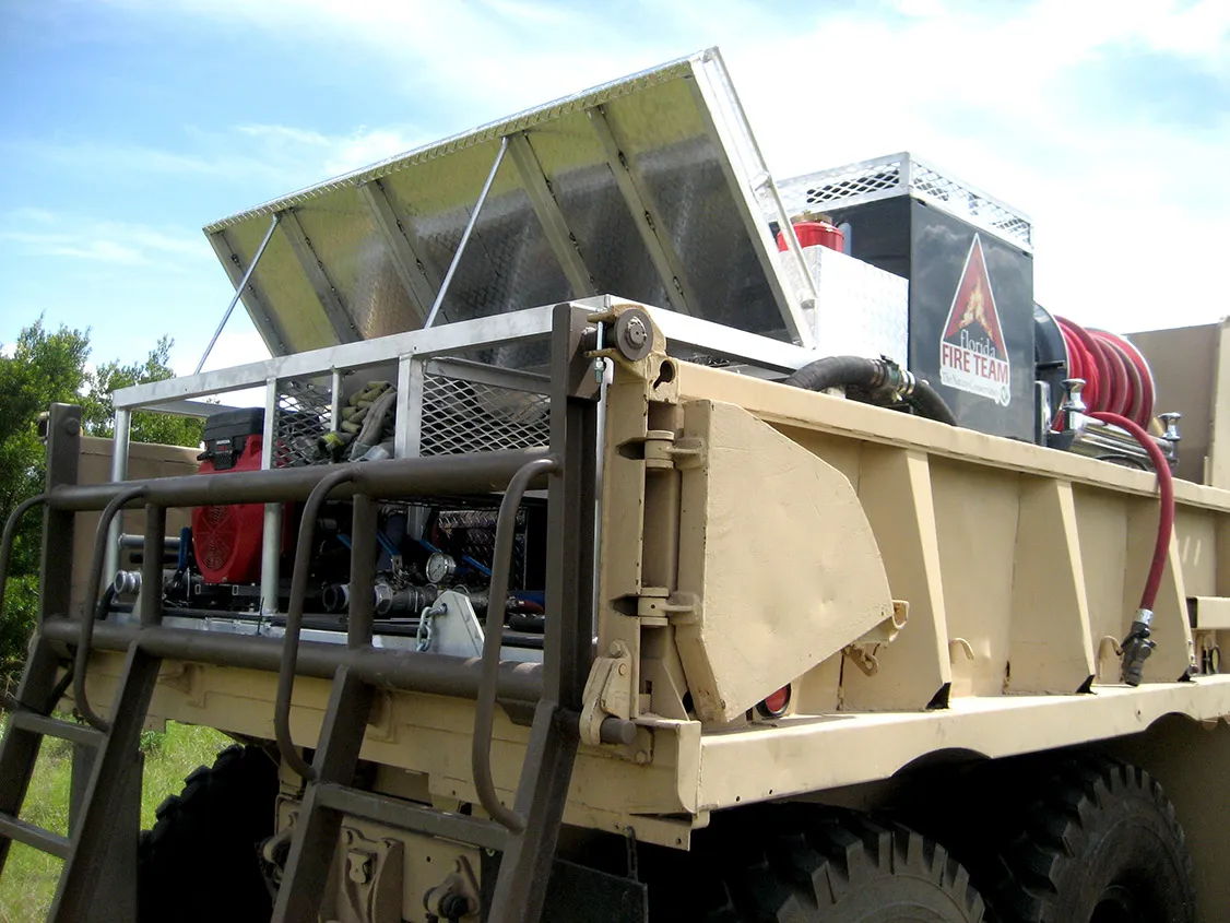 Southern Rough custom 5-ton wildland fire truck bed with hinged aluminum overhead storage, folded hose trays, Honda-powered BB-4 pump, and custom access ladder