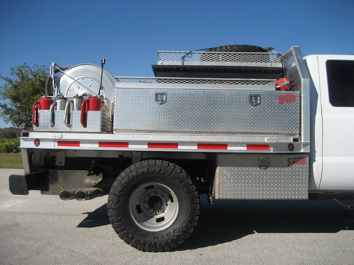 Southern Rough wildland fire engine passenger side showing diamond plate storage compartments, hose reel, drip torch rack, fire extinguisher mount, and top rack