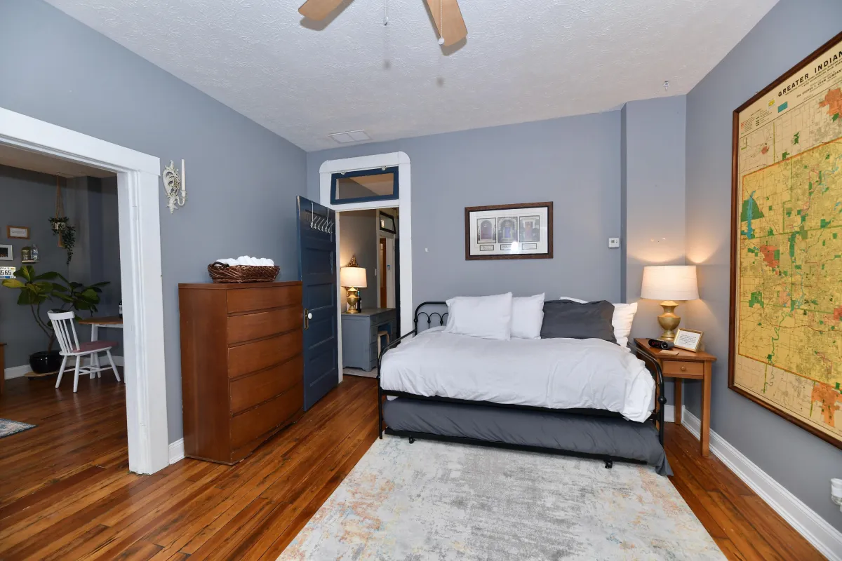 Furnished bedroom in a mid-term rental property in Indianapolis Indiana with vintage city map and hardwood floors