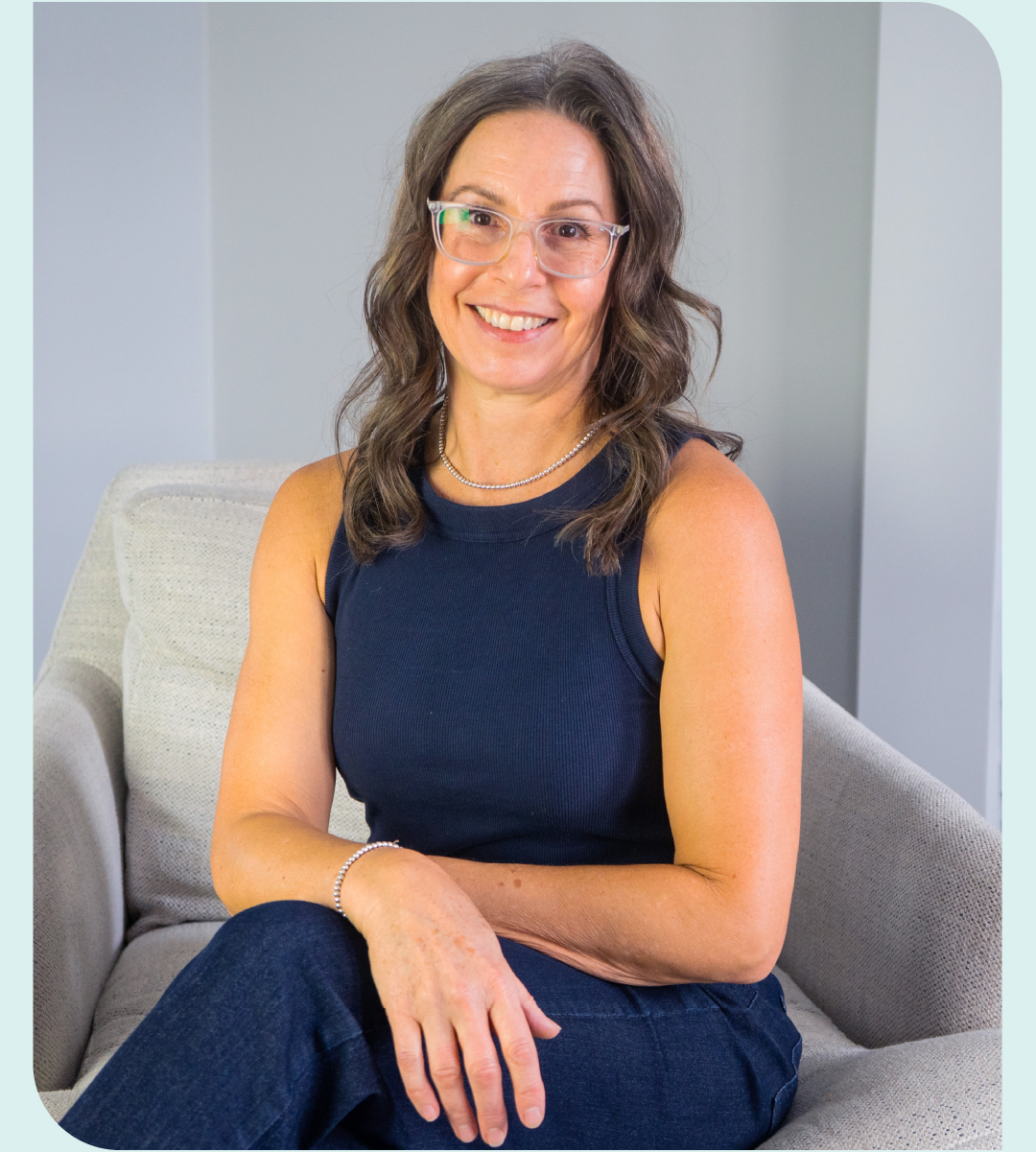 picture of Paula sitting on a chair with legs crossed