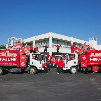 A row of green and blue trash cans next to a building