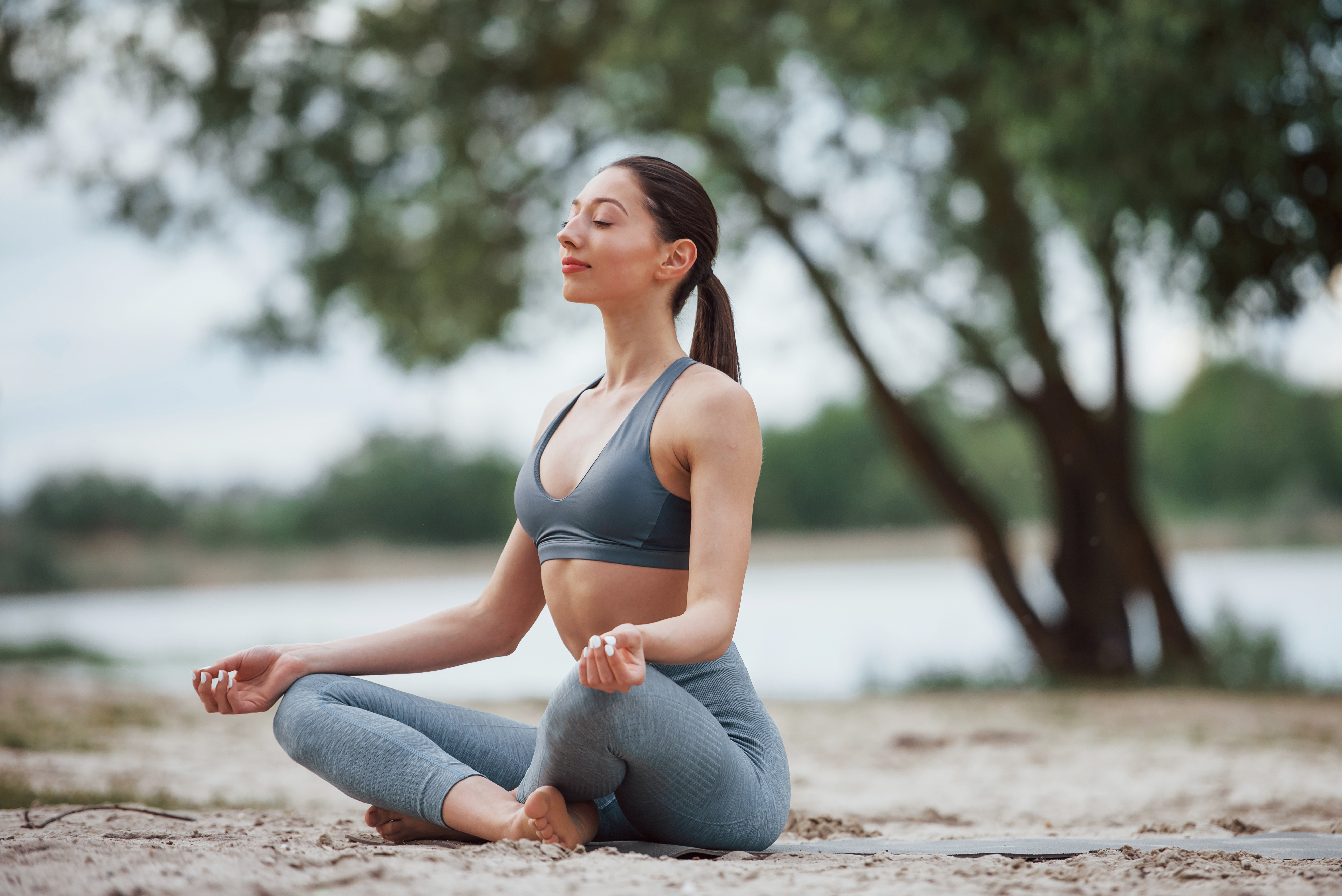 Woman practicing mindfulness yoga outdoors at sunset, focusing on breath and inner calm, embodying holistic wellness and mental clarity.