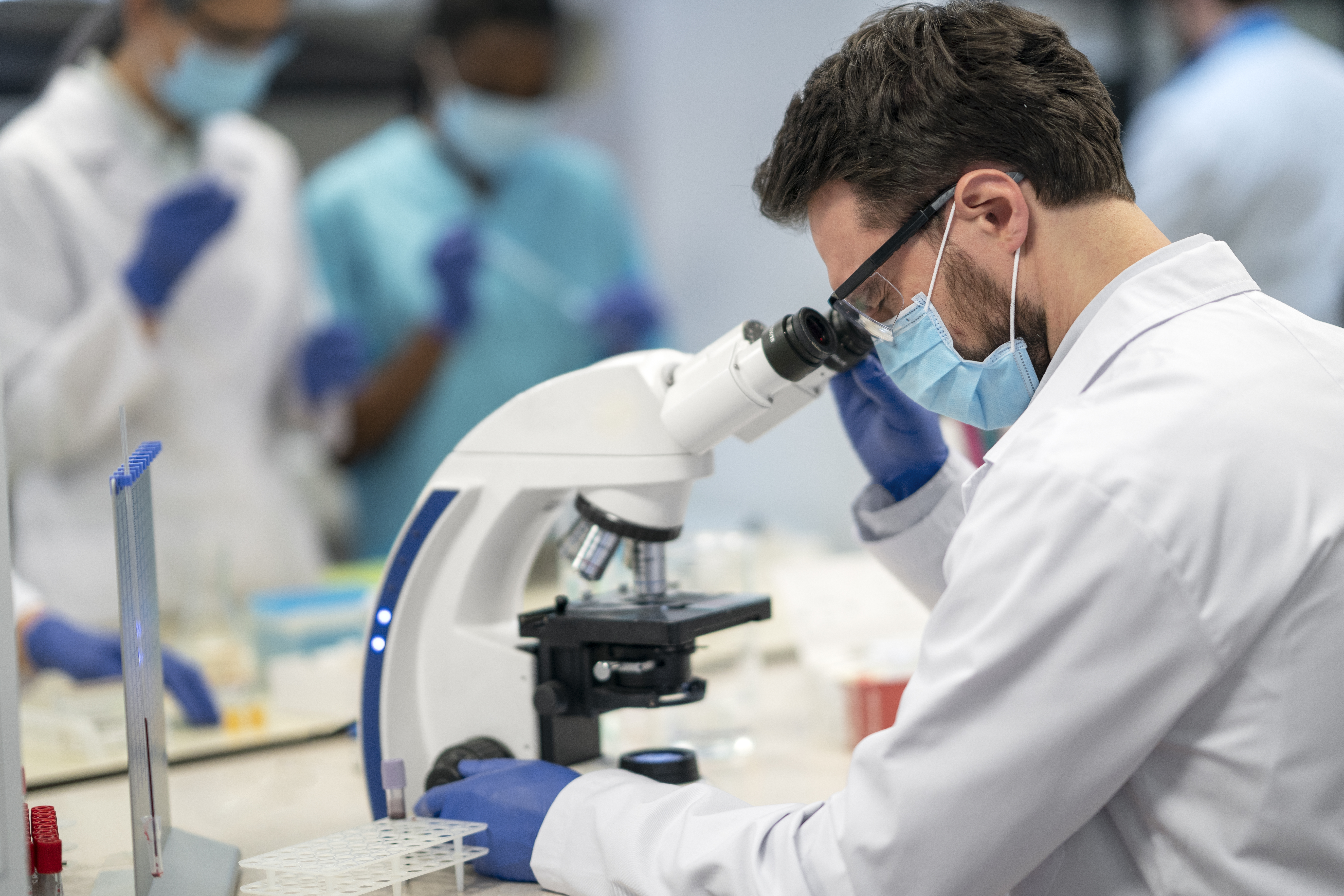 Woman performing an advanced yoga pose on a rocky beach, symbolizing strength and balance in a health transformation context.