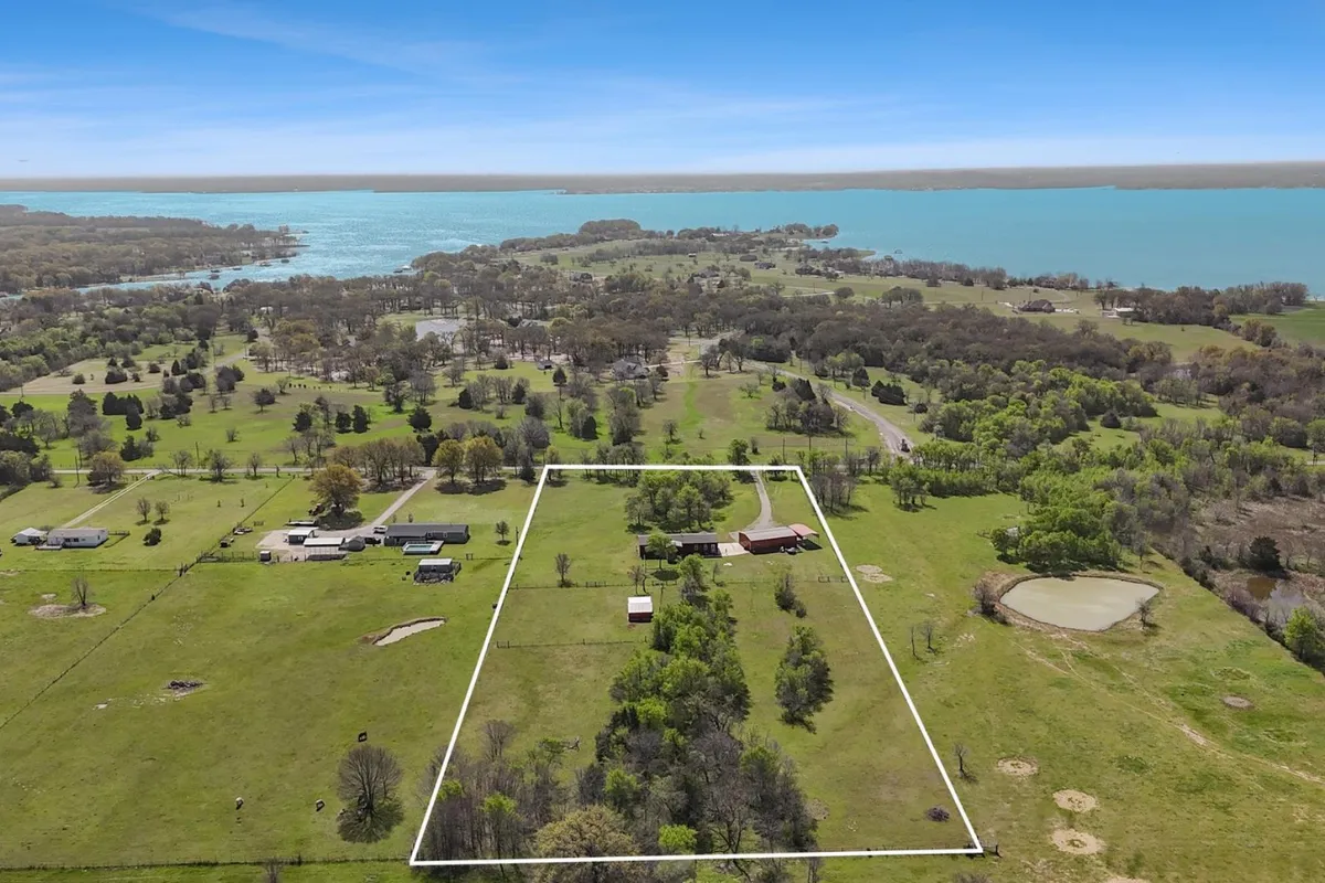 an aerial shot of home next to a lake with lot lines highlighted