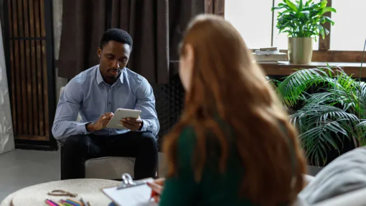 ACT therapy session at Cornerstone Wellness Center in Medina, OH, with therapist Amanda Hill and a young African American male client in a peaceful therapy room.
