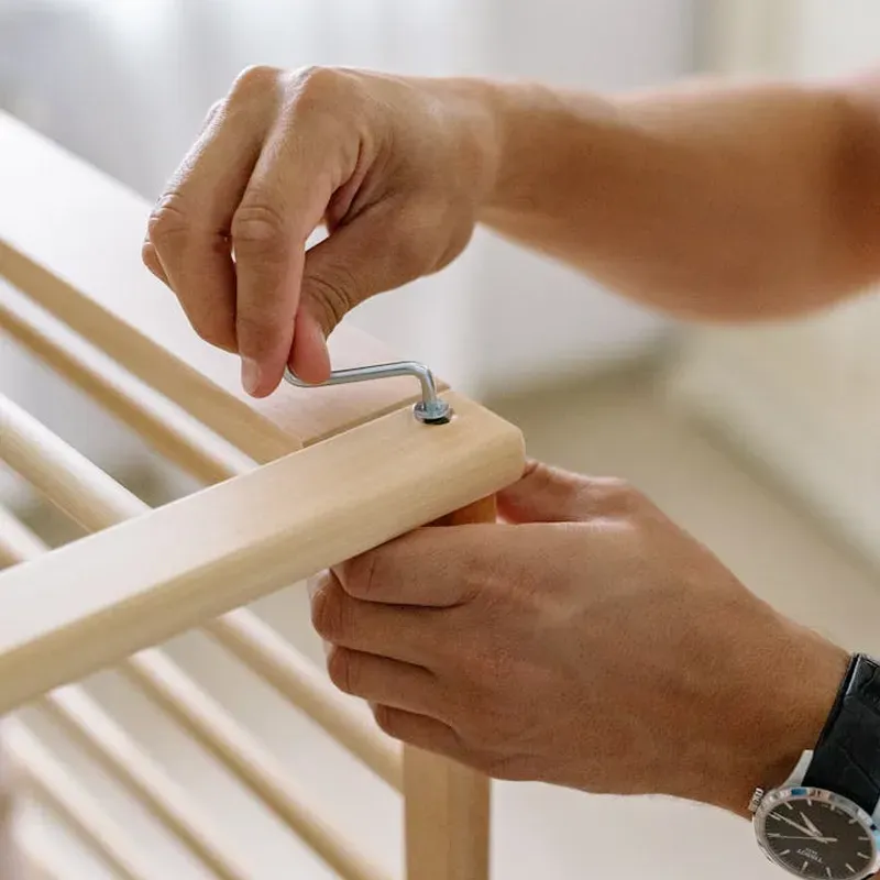 Image of a handyman assembling furniture inside of a home