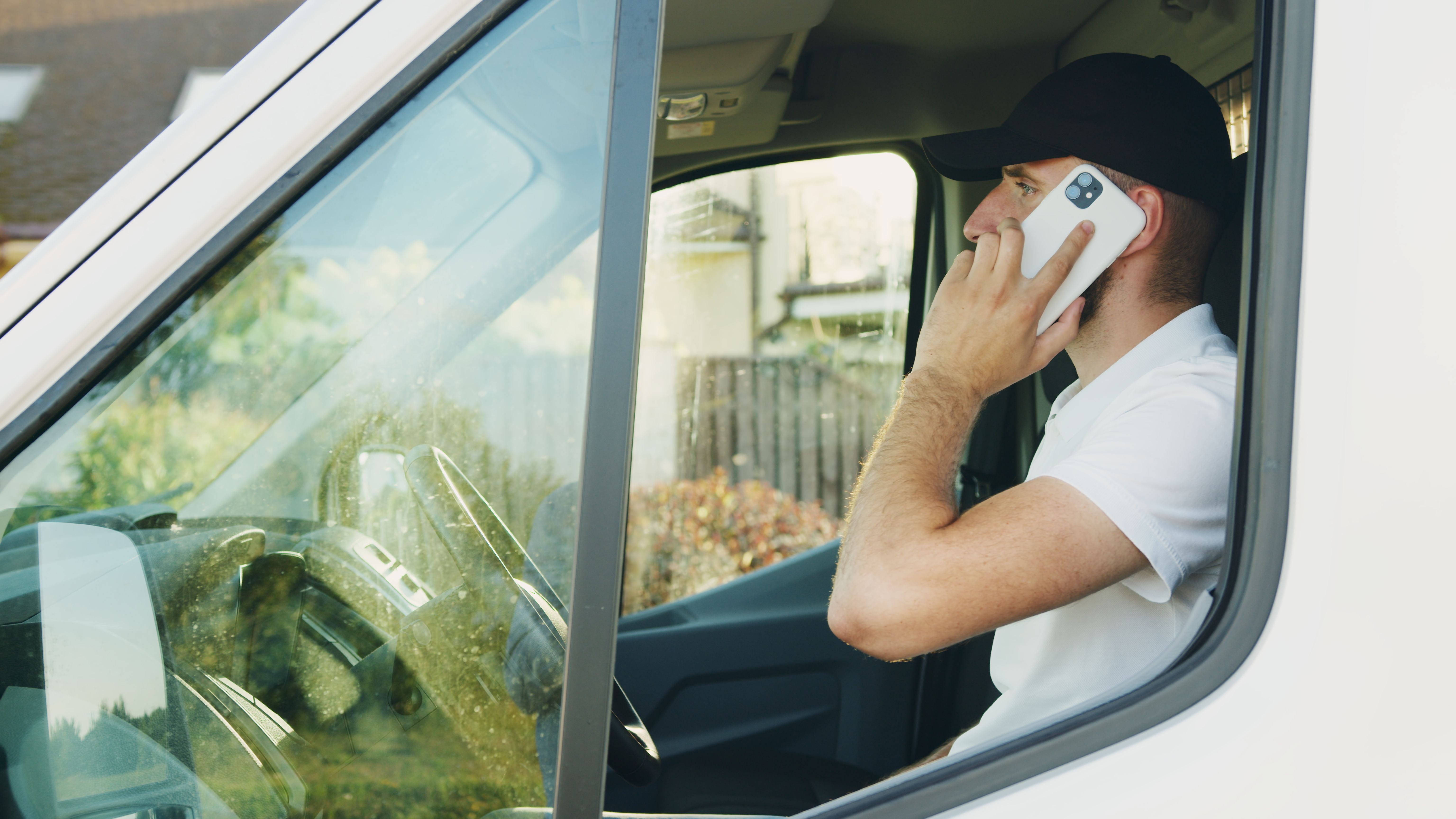 Home-service business owner taking a phone call in his work van