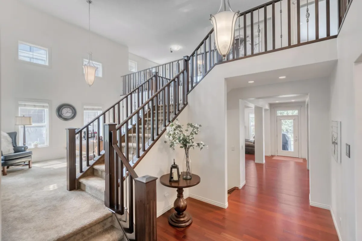 Interior of a large house with brown banisters red oak floor and pale oak colored walls painted by Alchemist Painting
