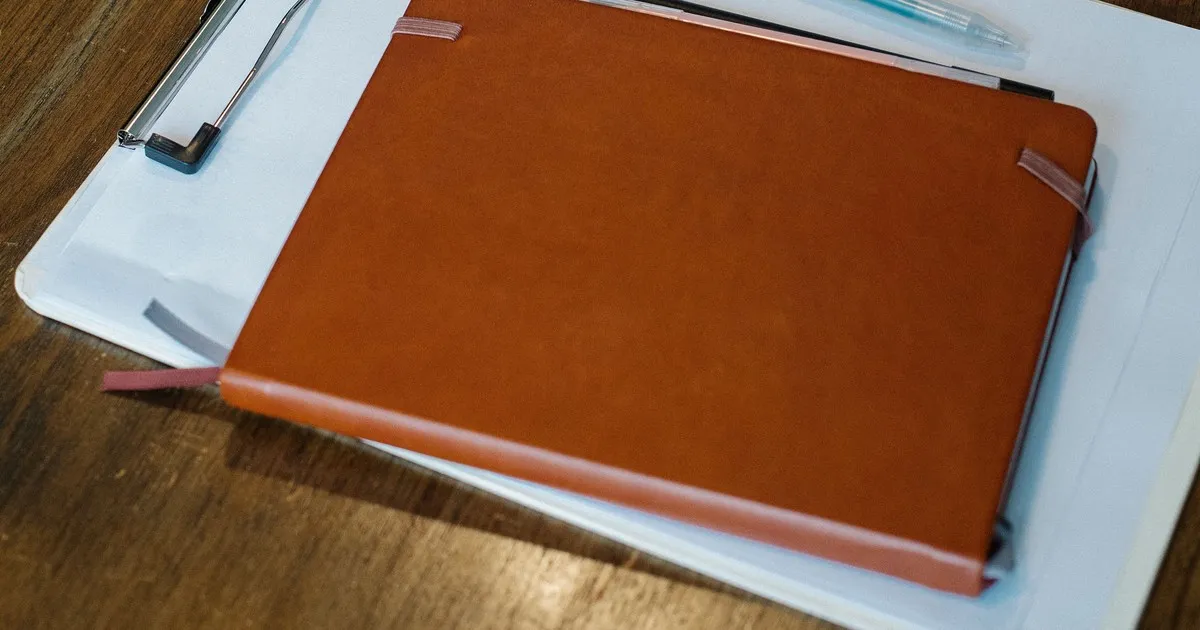 Clipboard, notebook, and paperwork organized on a desk, representing a consistent tenant screening process