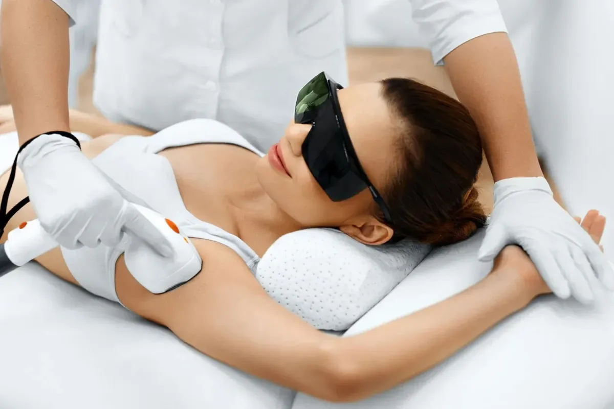 IPL hair removal treatment image: device over leg area, natural skin tones, clinical lighting and tasteful composition.