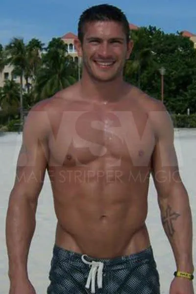  Athletic Male stripper Jay on the beach, shirtless in swim trunks